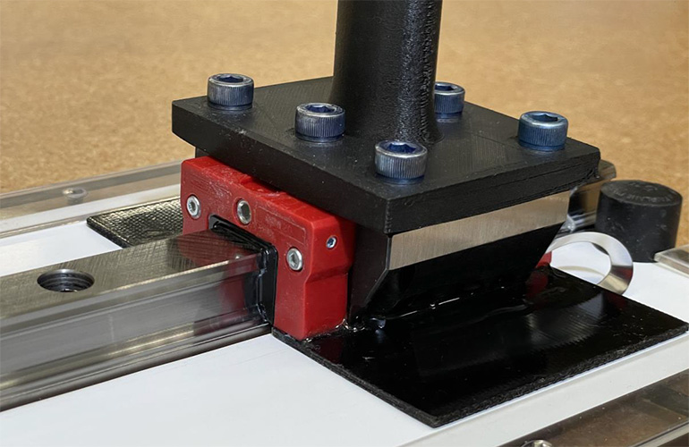 image of a linear axis with the ESTAT linear brake material next to the linear axis.