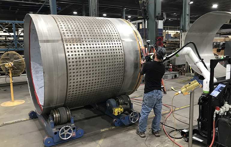 A worker manipulates a Kane cobot to instruct it.