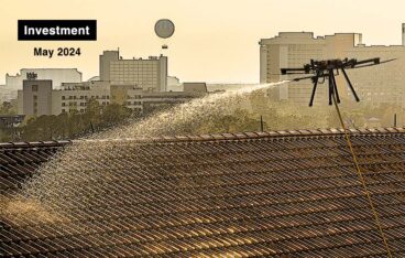 an aerial drone spraying liquid onto a roof