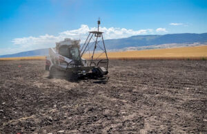 a terraclear tractor in a rocky, unplanted field.