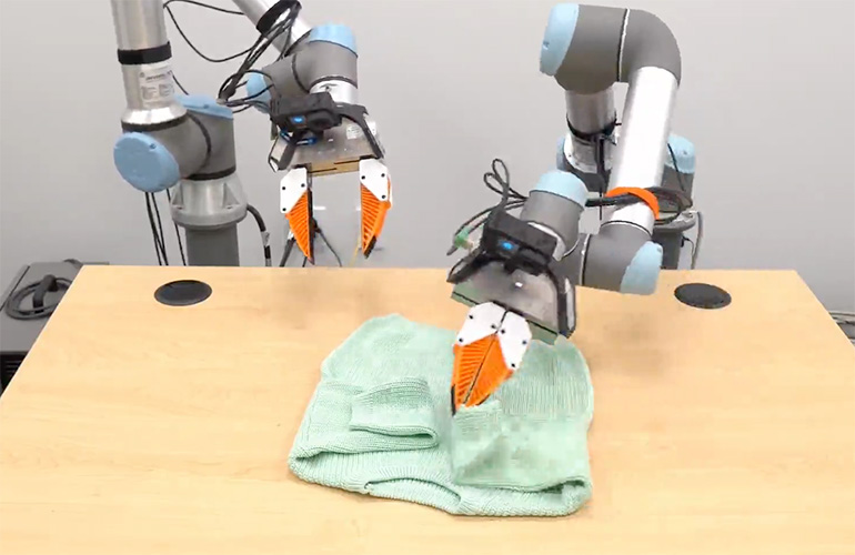 two UR cobots fold a shirt using UMI gripper.